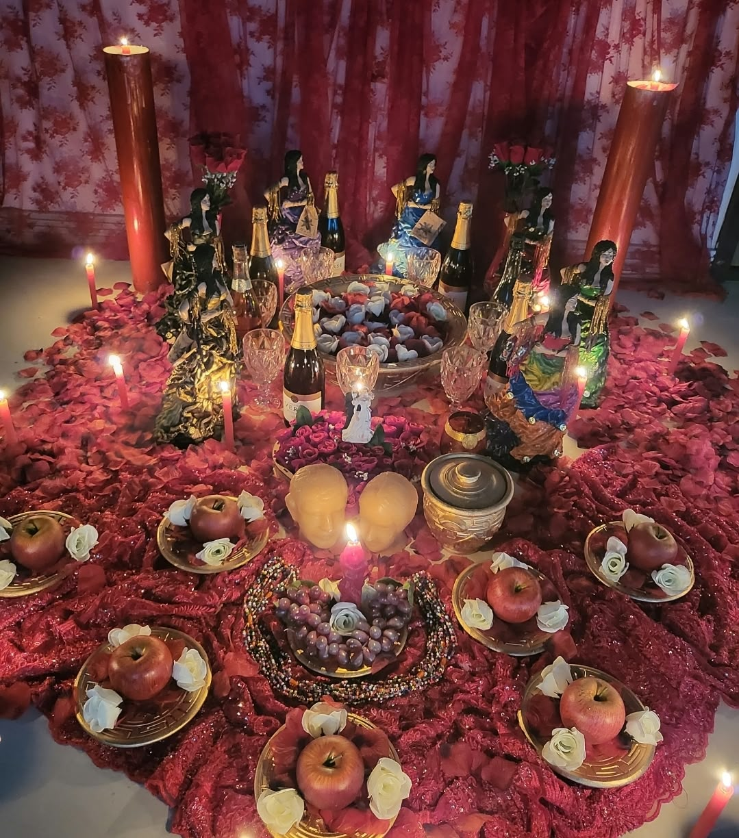 Altar iluminado com velas, frutas e imagens sagradas preparado para o trabalho